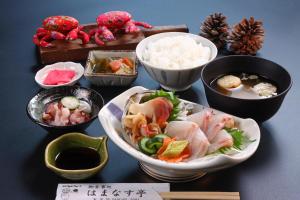 a table topped with bowls of food on a table at ゲストハウスはまなす亭 in Jōnai