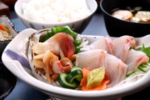 a white bowl of food with meat and vegetables at ゲストハウスはまなす亭 in Jōnai +9 photos