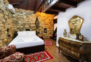 a bedroom with a bed and a mirror and a dresser at Guest House Nina in Berat