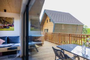 a balcony with a table and a couch on a deck at Streuobst Chalets in Neukirch