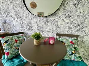 a table and two chairs with a table and a mirror at Le Ptit Germain in Saint-Germain-la-Blanche-Herbe +12 photos