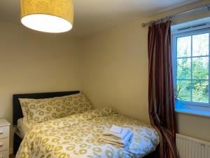 a bedroom with a bed with towels on it at Quiet Three-Bedroom Home in Stewartby with Ensuite and Workspace in Bedford