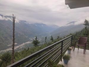 a balcony with a chair and a view of a valley at Devansh Homestay &Cafe in Kulu