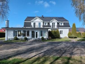 a white house with a black roof at Villa Antoja in Grzybowo