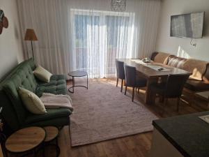 a living room with a green couch and a table at Haus Rupitsch in Winklern