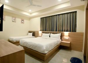 a bedroom with two beds and a window at hotel arya inn in Prayagraj
