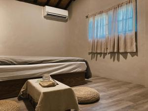 a bedroom with a bed and a table and a window at 楊桃墅民宿 in Chishang