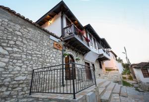 a building with a gate and a balcony at Guest House Nina in Berat
