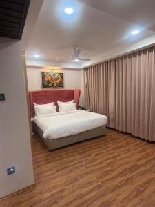 a bedroom with a bed with a red headboard at HOTEL NILACHAL - 10 Mins Travel to Kamakhya Temple, Guwahati in Guwahati