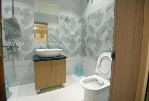 a bathroom with a sink and a toilet at hotel arya inn in Prayagraj +12 photos