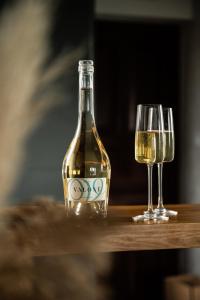 a bottle of wine and two glasses on a table at VALONÉ Villány in Villány +19 photos