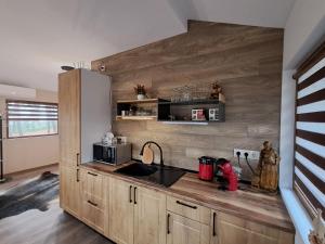 a kitchen with wooden cabinets and a counter top at Къща Шепотът на бора in Varna City