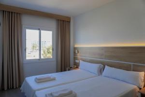 a hotel room with two beds and a window at ENDLSS BEACH & DISCO HOTEL IBIZA Adults Only in San Antonio Bay +84 photos