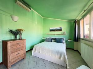 a green bedroom with a bed and a wooden dresser at Dimora le tagliate in Lucca