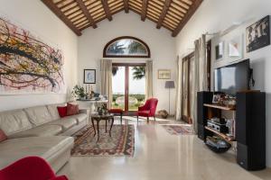 a living room with a couch and a tv at Villa Casale by PosarelliVillas in Bisciano