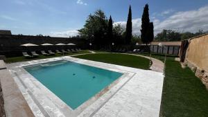 a large swimming pool in a yard with trees and grass at Hospedería del Monasterio de Rueda in Sástago
