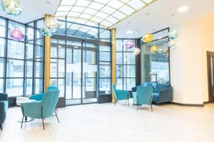 a waiting room with blue chairs and windows at Pilvax Hotel Budapest in Budapest