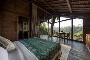 a bedroom with a large bed and a table at Bumi Kabins Ubud in Tegalalang