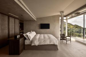 a bedroom with a bed and a chair and a television at Daybreak in Jiufen +107 photos