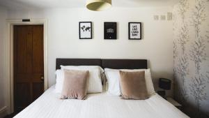 a bedroom with a bed with white sheets and pillows at No.8 Accommodation in Chepstow