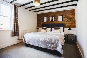 a bedroom with a large bed and a brick wall at No.8 Accommodation in Chepstow