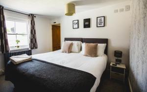 a bedroom with a bed with white sheets and pillows at No.8 Accommodation in Chepstow +18 photos