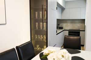 a dining room with a table with white flowers on it at Nest apartament in Peje +15 photos