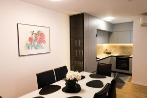 a dining room with a table and chairs and a kitchen at Nest apartament in Peje