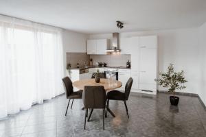 a kitchen with a table and chairs in a room at Riedwohnung 2 in Lustenau