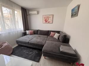 a living room with a couch and a window at Sweet Escape Varna in Varna City