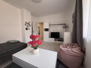 a living room with a couch and a table with flowers at Sweet Escape Varna in Varna City