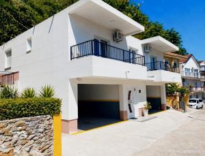 a white house with a garage in front of it at Bay Horizon View in Igalo