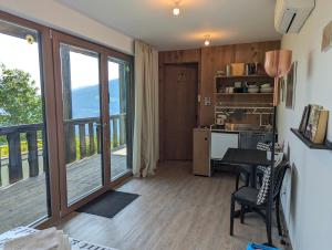 a room with a kitchen with a table and a balcony at artlodge TinyHouses in Treffen
