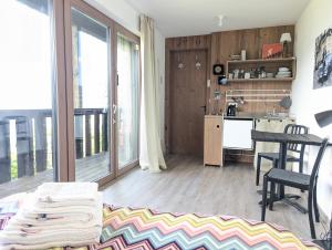 a living room with a table and a kitchen at artlodge TinyHouses in Treffen +9 photos