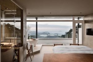 a bedroom with a bed and a large window at Daybreak in Jiufen