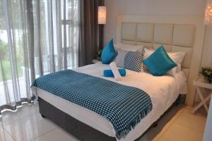 a bedroom with a large bed with blue pillows at 34 on Milkwood in Durban