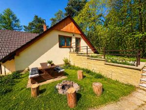 a house with a yard with logs in front of it at Atik V Borovičkách in Lipuvka