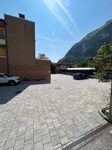 a parking lot in front of a building with two cars at I Castelli - Alle 5 Torri in Mezzolombardo