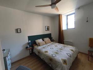 a bedroom with a bed and a ceiling fan at Sur la Draille in Le Vigan