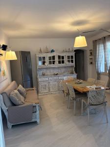 a living room with a table and a kitchen at House Mia in Cala Liberotto
