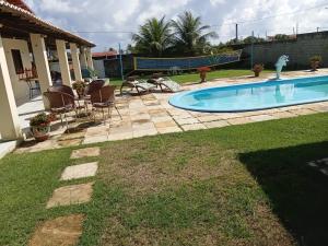 a yard with a swimming pool and a patio at Casa de praia Morro Branco in Beberibe +35 photos