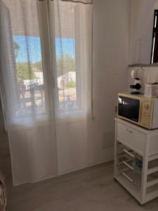 a living room with a microwave and a window at House Mia in Cala Liberotto
