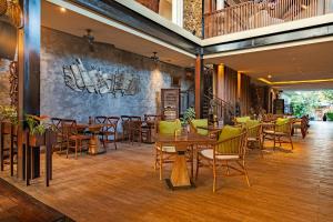 a restaurant with wooden tables and chairs in a room at Plataran Ubud Hotel & Spa in Ubud