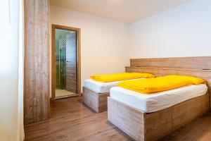 two twin beds in a room with a mirror at Rifugio Capanna Bill in Rocca Pietore