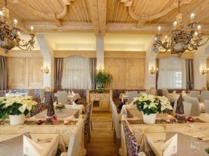 a dining room with tables and chairs and chandeliers at Hotel Goldene Rose in Reutte