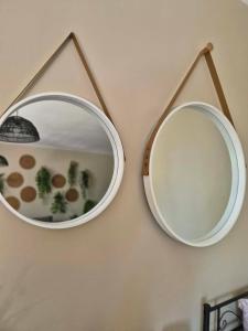 two mirrors are hanging on a wall at Pokój 102 Boho in Nasutów