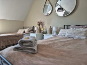 a bedroom with two beds and a mirror on the wall at Pokój 102 Boho in Nasutów