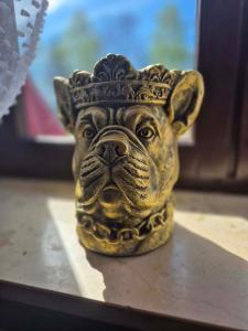 a statue of a dog with a crown on its head at Pokój 102 Boho in Nasutów