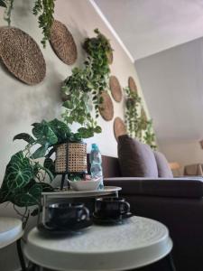 a living room with a couch and plants on the wall at Pokój 102 Boho in Nasutów