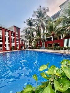 a large blue swimming pool in front of buildings at Subtlestays in Arpora